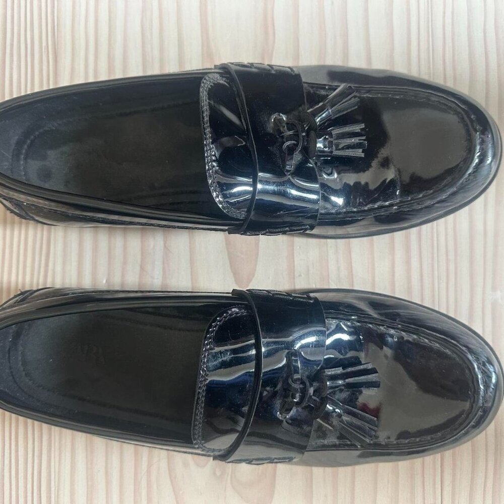 Black patent leather loafers with tassel deta
